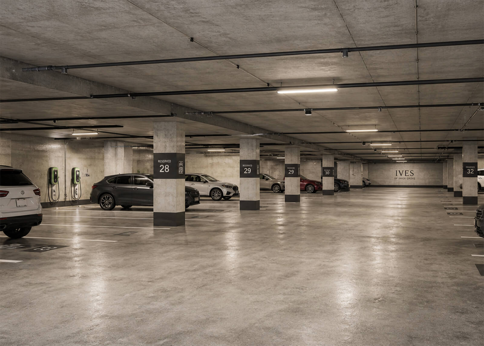Underground parking garage with reserved spaces, EV charging stations, and Ives of Inver Grove signage