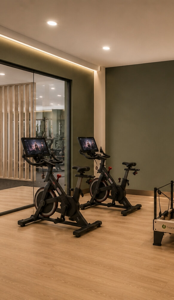 Fitness center with spin bikes, wood flooring, and glass-walled workout space