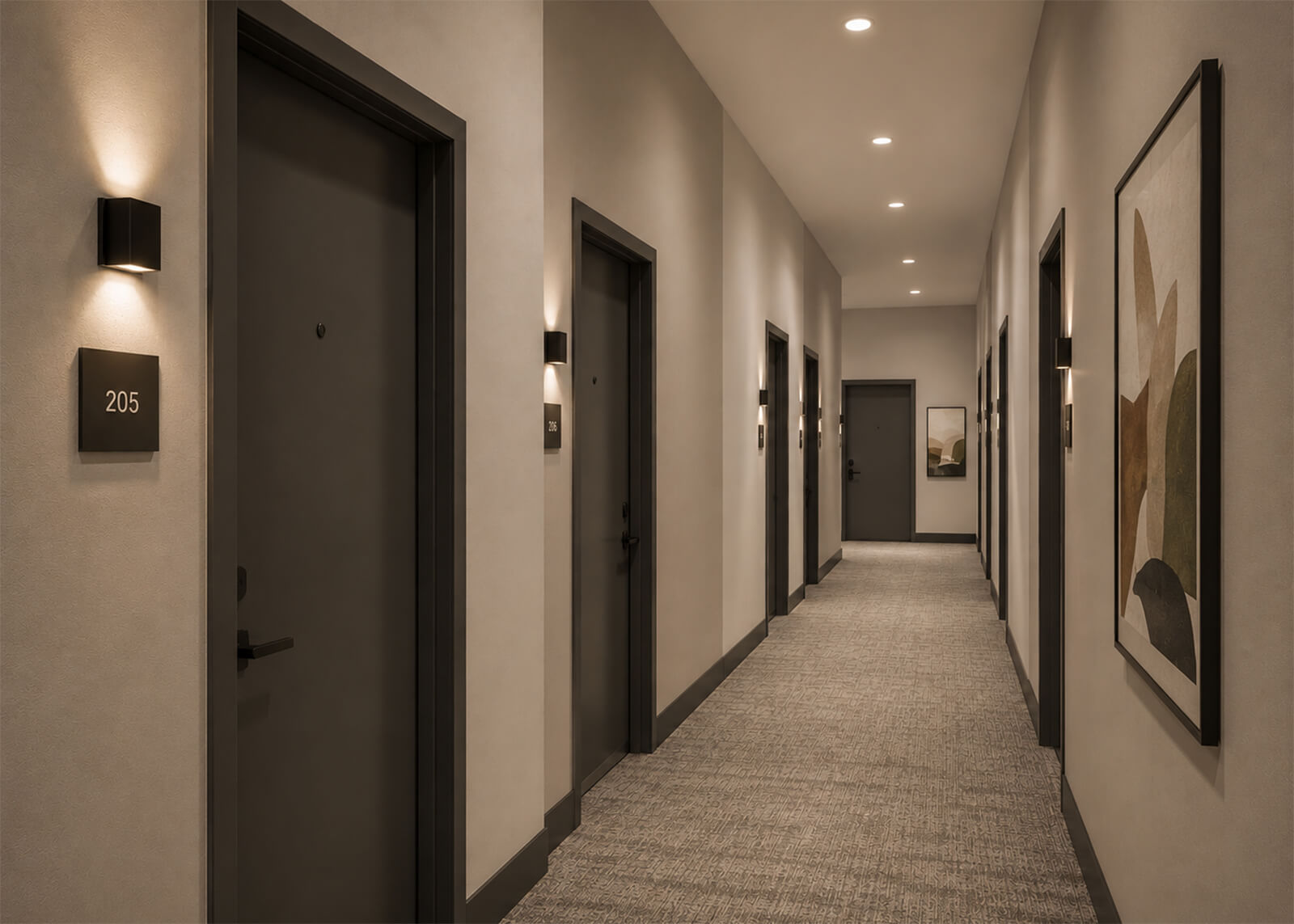 Apartment hallway with dark doors, wall sconces, framed artwork, and patterned carpet